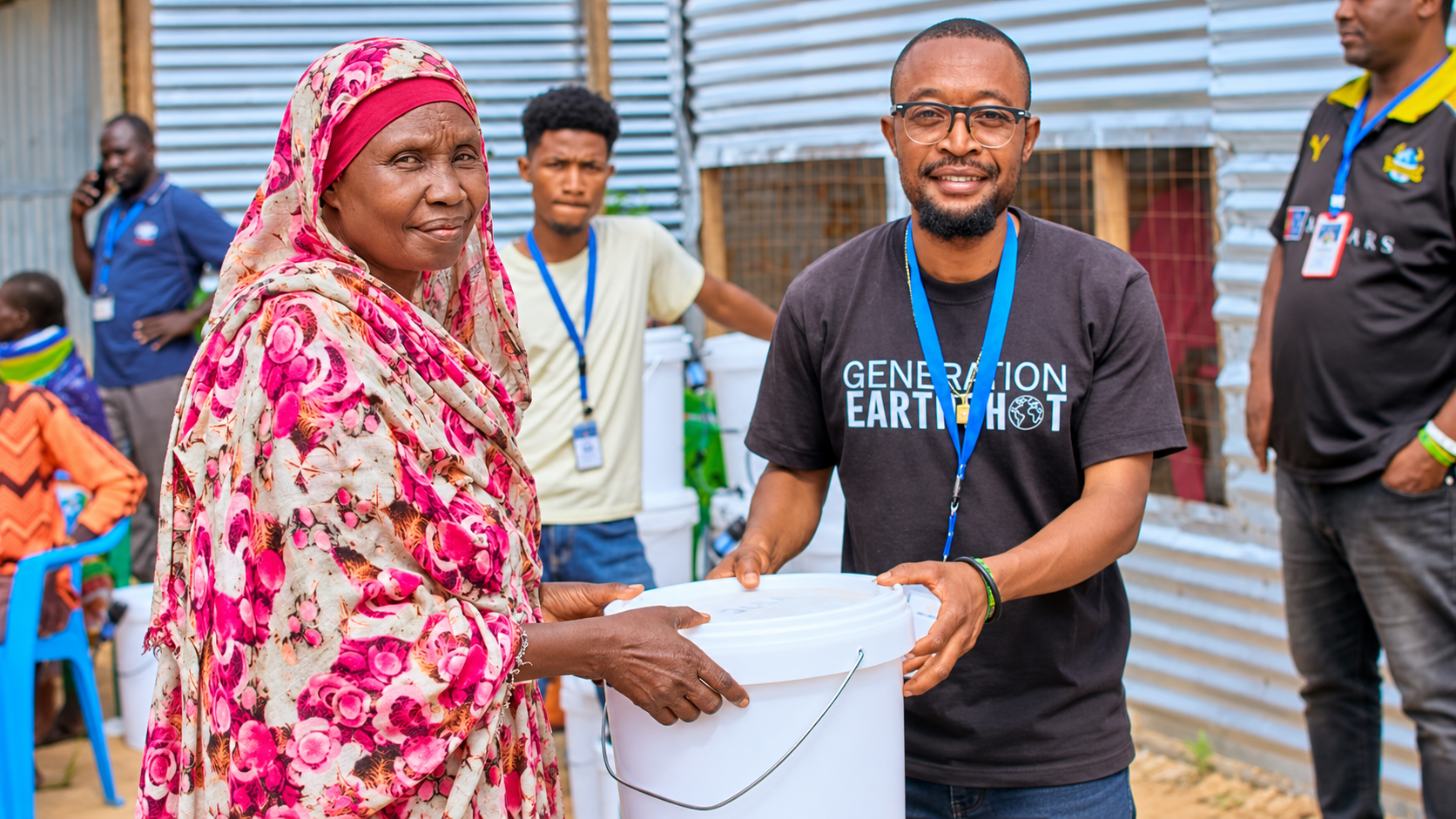 Volunteer handing a filtration bucket to an older community member