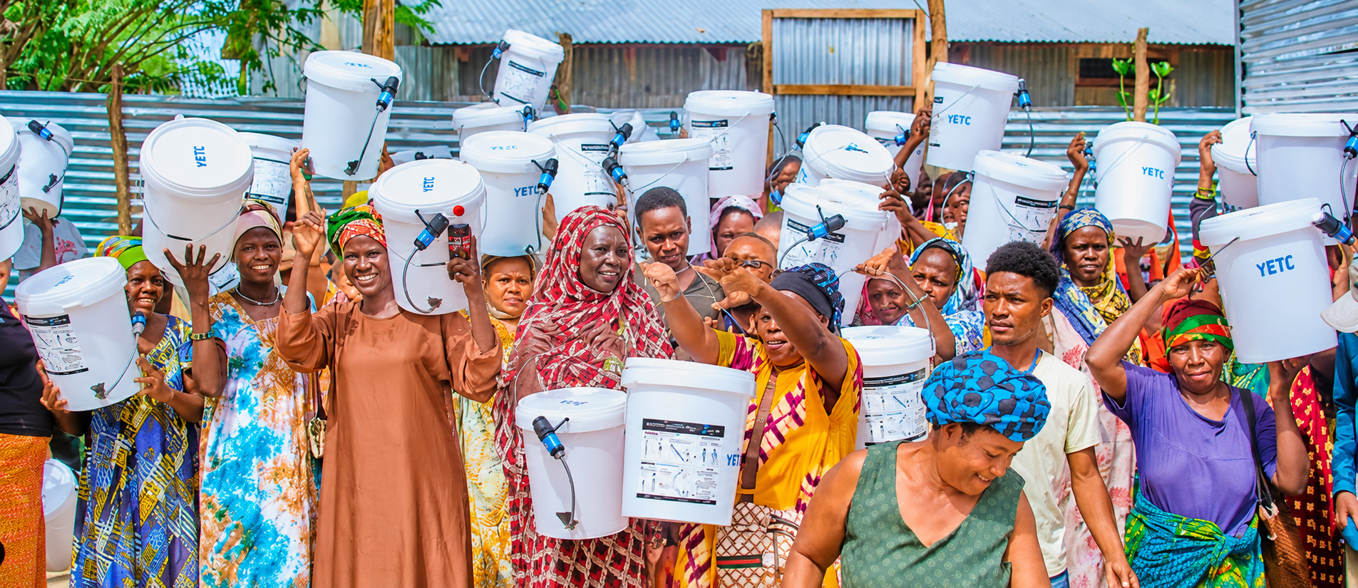 Community members carrying Safer Cleaner Water filtration buckets